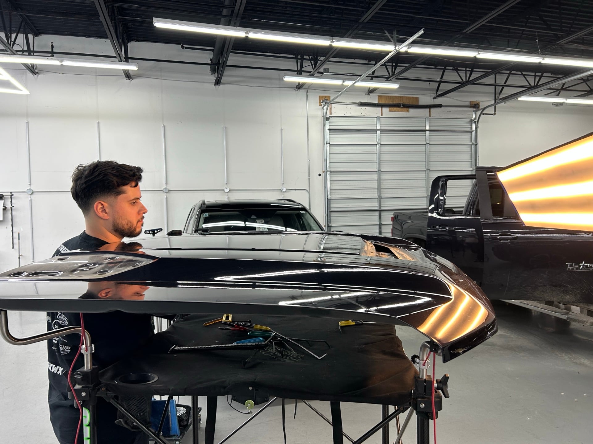 Professional auto hail repair work in progress showing dent removal process